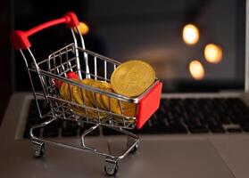 Bitcoin token in a trolley toy on laptop. Bitcoin is one of the popular cryptocurrency, a virtual currency or a digital currency. photo