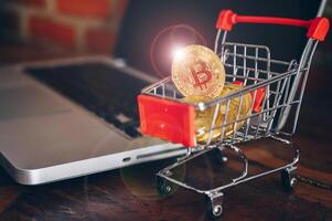 Bitcoin token in a trolley toy on laptop. Bitcoin is one of the popular cryptocurrency, a virtual currency or a digital currency. photo