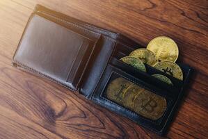 Group of Bitcoin token in leather wallet. Bitcoin is one of the popular cryptocurrency, a virtual currency or a digital currency. photo
