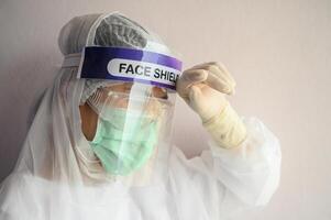 Nurse having headache and tired while wearing PPE suit for protect coronavirus disease. PPE while protecting healthcare workers from exposure to the COVID-19 virus in healthcare settings. photo