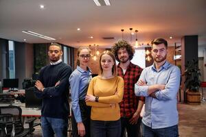 Portrait of successful creative business team looking at camera and smiling. Diverse business people standing together at startup. Selective focus photo