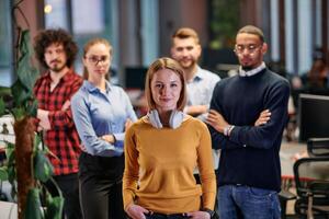 Portrait of successful creative business team looking at camera and smiling. Diverse business people standing together at startup. Selective focus photo