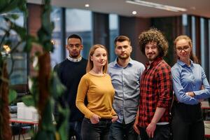 Portrait of successful creative business team looking at camera and smiling. Diverse business people standing together at startup. Selective focus photo