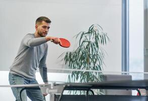 Business colleagues take a break from work to enjoy a game of table tennis, fostering teamwork and camaraderie in the workplace photo