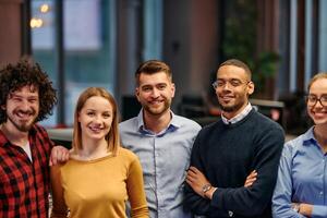 Portrait of successful creative business team looking at camera and smiling. Diverse business people standing together at startup. Selective focus photo
