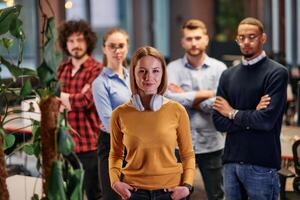 Portrait of successful creative business team looking at camera and smiling. Diverse business people standing together at startup. Selective focus photo