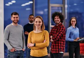 Portrait of successful creative business team looking at camera and smiling. Diverse business people standing together at startup. Selective focus photo