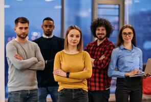Portrait of successful creative business team looking at camera and smiling. Diverse business people standing together at startup. Selective focus photo