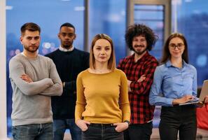 Portrait of successful creative business team looking at camera and smiling. Diverse business people standing together at startup. Selective focus photo