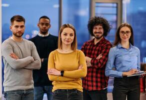 Portrait of successful creative business team looking at camera and smiling. Diverse business people standing together at startup. Selective focus photo
