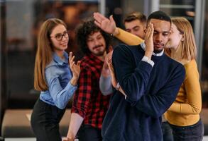 A group of young business people have fun playing interesting games while taking a break from work in a modern office. Selective focus photo