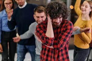 A group of young business people have fun playing interesting games while taking a break from work in a modern office. Selective focus photo