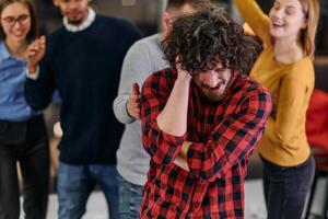 A group of young business people have fun playing interesting games while taking a break from work in a modern office. Selective focus photo