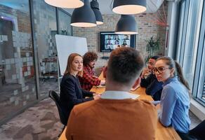 In the vibrant ambiance of a modern startup office, a diverse team of business professionals engage in discussions on various projects and develop new business strategies, epitomizing creativity and photo