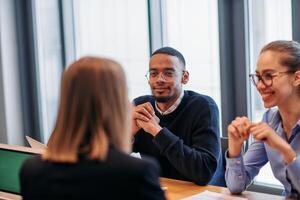 In the vibrant ambiance of a modern startup office, a diverse team of business professionals engage in discussions on various projects and develop new business strategies, epitomizing creativity and photo