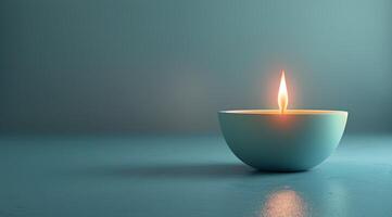 A Single Lit Candle in a Blue Setting photo