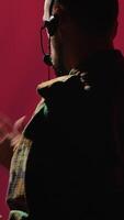 Vertical Military dispatcher providing informations for troops on war front lines, talking in headset microphone. Radio communications operator in uniform coordinating troops, camera A video