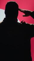 Vertical Conscript doing saluting hand gesture towards North Korea flag in command center, showing respect. Military unit in uniform serving in Korean Peoples Army, doing honoring gesturing, camera A video