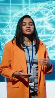 Vertical Tech company CEO using conference as platform to present latest AI services. Woman uses microphone to talk at convention with business investors interested in artificial intelligence, camera A video
