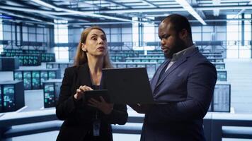 Manager in data center supervising worker running error checking utilities to fix errors. Supervisor in server farm overseeing engineer repairing network issues affecting rigs performance, camera A video