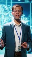 Vertical Presenter talking in front of world leading technology specialists and researchers meeting at artificial intelligence conference. Data scientist showcasing latest innovations in AI industry, camera A video