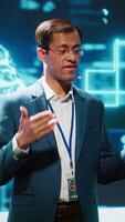 Vertical Smiling public speaker hosting AI convention gathering tech startups managers and academics. IT expert moderating symposium, teaching industry workers how to tap into artificial intelligence, camera A video
