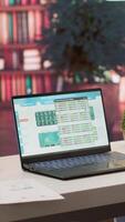 Vertical Empty home setup belonging to an entrepreneur with data sales analytics and financial reports on laptop, accountancy information and invoices for remote work. Finance and economy. video