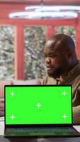 Vertical Small business owner works on finances plans next to a green screen, using annual sales analytics to increase startup profit. Entrepreneur does budget balance analysis at home desk. Camera B. video