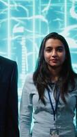 Vertical Portrait of smiling team of technicians implementing artificial intelligence parallel processing, breaking up complex computational tasks enabling AI systems to process data faster, camera A video