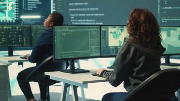 Group of governmental hackers using hacking tools to secure a network, focusing on cyber defense and data protection measures. Experts team examining important information on big screen. Camera A. video