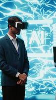vertical técnico vestindo vr fone de ouvido parece às holograma do artificial inteligência humano cérebro simulação, assistido de colega usando computador portátil. equipe do programadores interagindo com ai visualização, Câmera uma video