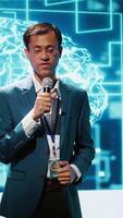 Vertical Speaker does presentation during tech conference, exploring successful implementation of AI in driving forward startup businesses, sharing latest machine learning discoveries, camera A video