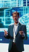 Vertical Smiling public speaker hosting AI convention gathering tech startups managers and academics. IT expert moderating symposium, teaching industry workers how to tap into artificial intelligence, camera B video
