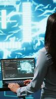Vertical Computer scientist in startup doing advancements in AI field. Woman working on laptop in cutting edge workspace featuring artificial intelligence and neural network systems, camera A video