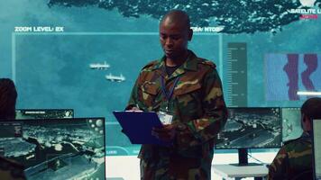 Navy captain oversees collecting important data for a national defense mission, targeting enemy vessels with the satellite radar system. Reconnaissance in a military base of operations. Camera A. video