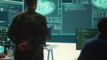 Military personnel working in a government cyber defense center, cyber attack prevention. Soldiers team securing sensitive data from spyware, ransomware and other malware threats. Camera A. video