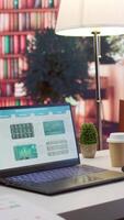 Vertical Empty home office with tablet and laptop showing infographics and accounting data, financial business reports. Space used for a specialist to study the market and work on economy analysis. video