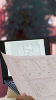 Vertical Business owner conducting strategic research on office spaces and building layouts, using blueprints and sketches to draft and organize a new creative workspace. Office hunt relocation. Camera A. video