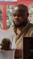 Vertical Business owner looks into project development online from home office setup, working on new strategies. Freelancer analyzing data statistics and reports on laptop, telecommuting methods. Camera B. video