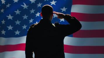 American soldier doing saluting hand gesture towards USA flag in command center, showing respect. Military unit in uniform serving in United States Armed Forces, doing patriotic gesturing, camera A video