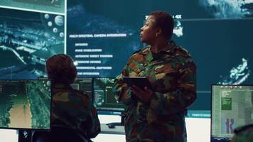 Woman sergeant major working on deployment of electronic warfare tools to disrupt enemy communications. Female army soldier with camouflage uniform operating on high tech gear. Camera A. video