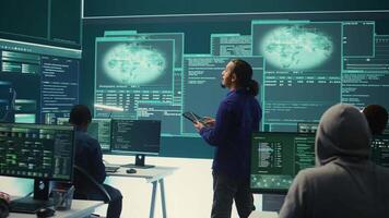 Group of professional hackers gaining access into government database to steal important information for hybrid warfare. Experts work on scams and phishing activity in high tech office. Camera B. video