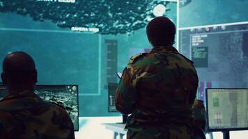 Woman colonel handling a special operation with big data in monitoring room, providing important satellite information to her crew in command post. Targeting enemy power base. Camera A. video