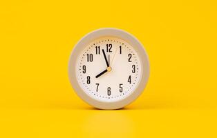 Alarm clock, stationary on a yellow background, concept of time and working with time. photo