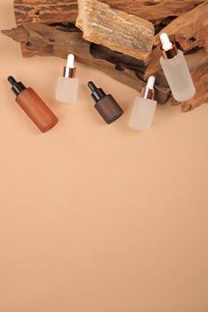 Assorted Glass Dropper Bottles for Skincare and Aromatherapy on Rustic Background photo