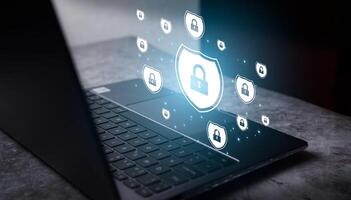 Laptop on desk with protection holographic interface. Digital cyber security. Security and privacy data protection concept. Lock icon shield for internet network security technology. photo