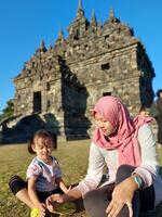 Mother and child enjoy a holiday with a view of Plaosan temple, good for blog, ads, template, banner etc photo