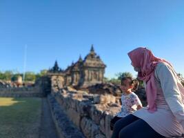 Mother and child enjoy a holiday with a view of Plaosan temple, good for blog, ads, template, banner etc photo