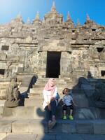 Mother and child enjoy a holiday with a view of Plaosan temple, good for blog, ads, template, banner etc photo