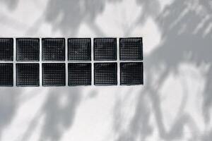Empty white Cement wall with Clear block for light to pass through the wall texture Background with shadow leaves overlay Sunlight well free space for text presentation on Concrete Wall Background. photo